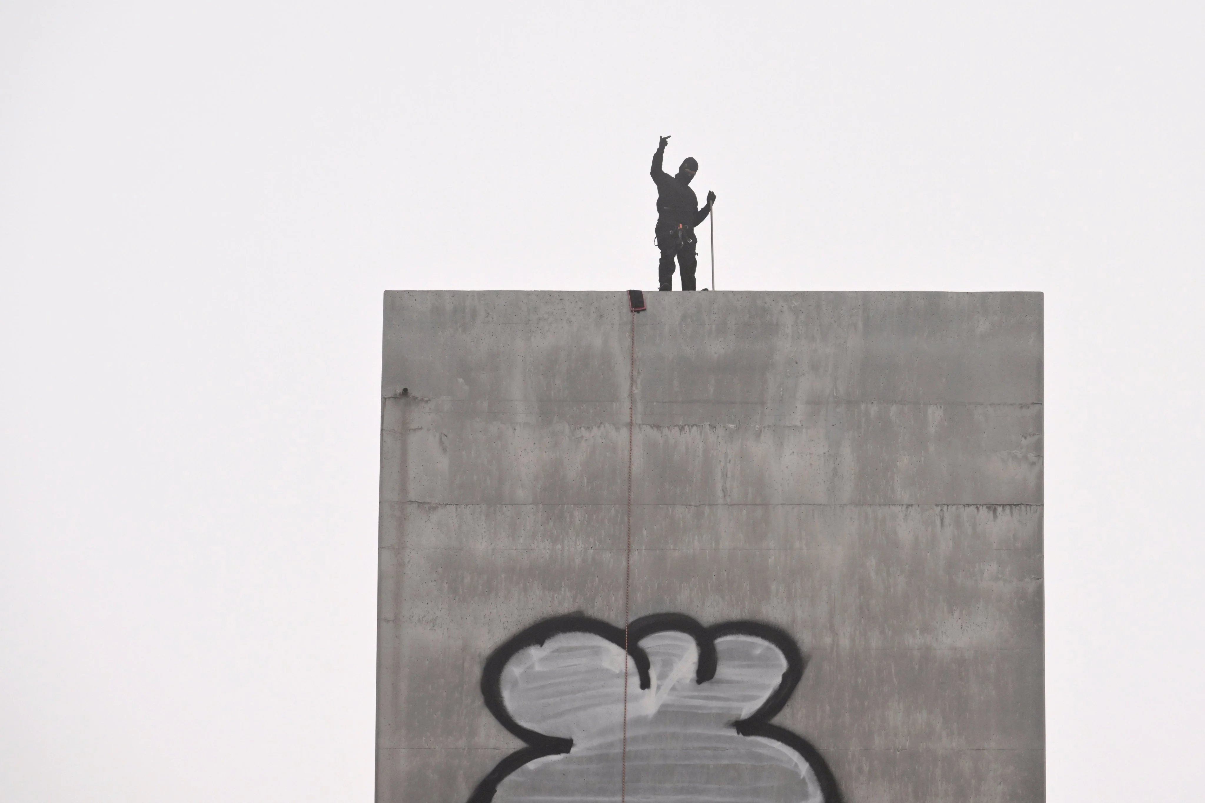 A man gestures from the top of the eastern pylon of the Bolte Bridge in Melbourne on Tuesday. Photo: EPA