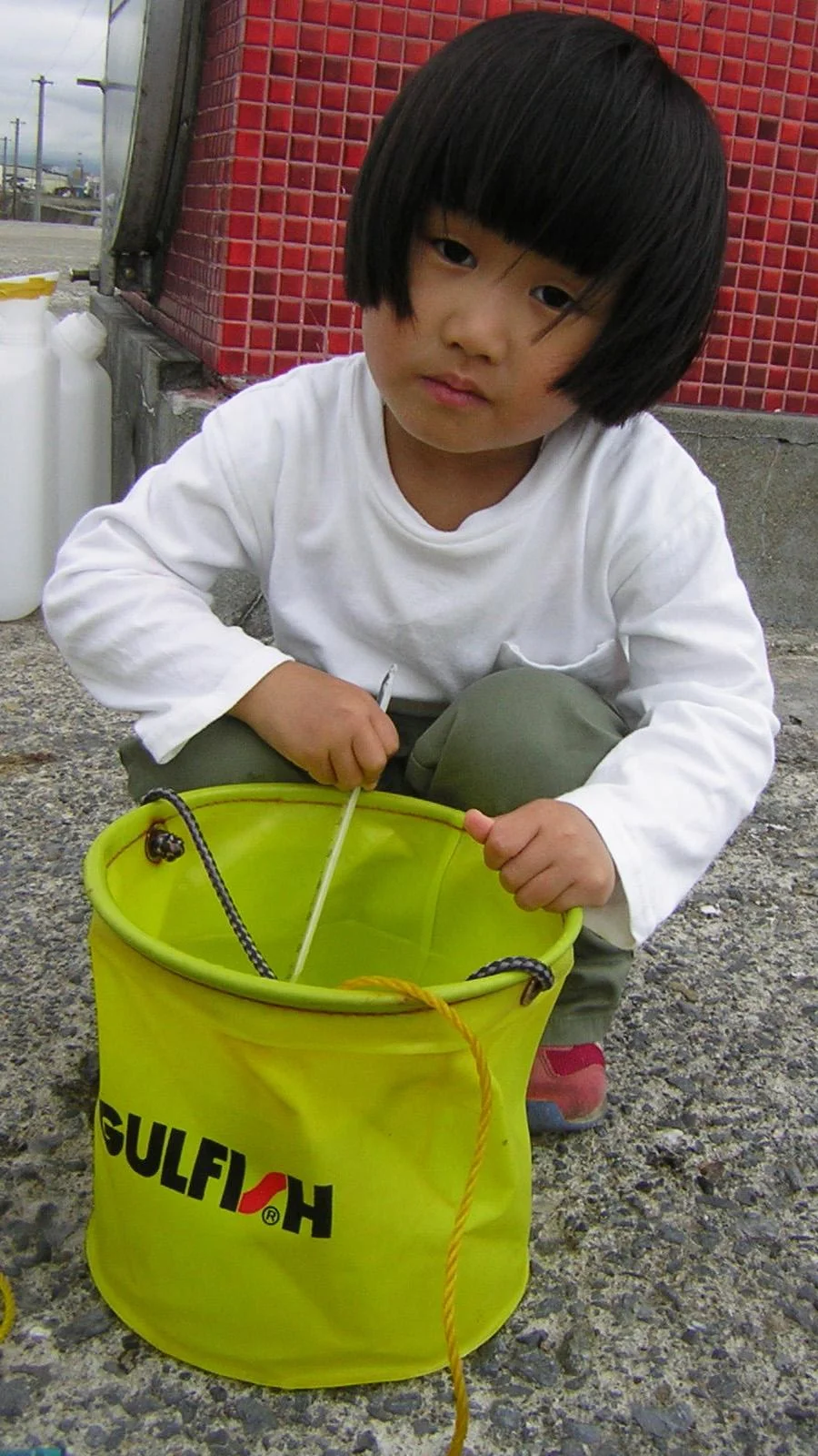 A child holds a bucket of seawater