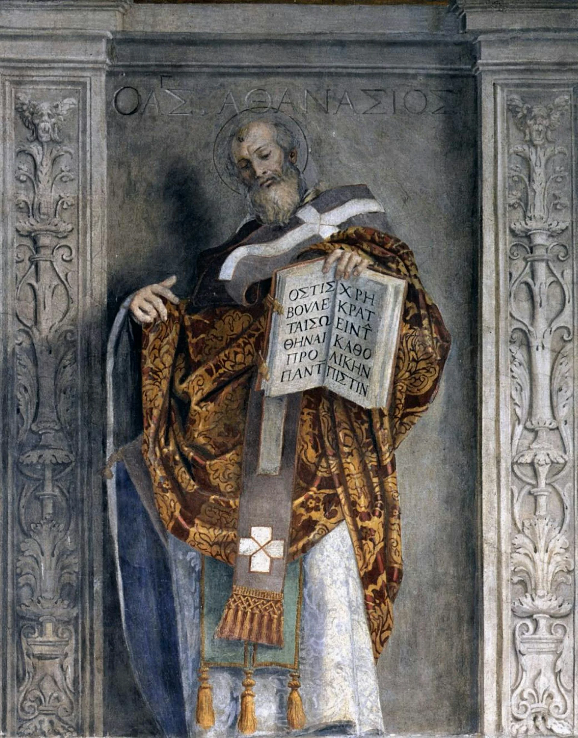 A bearded figure in an orange and brown robe gestures toward a large open book that he holds in one hand.