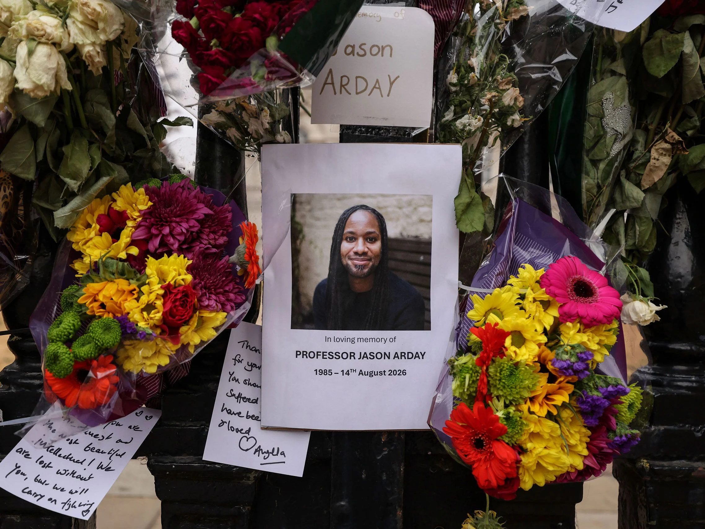 Photograph of Jason Arday next to bouquet of flowers.