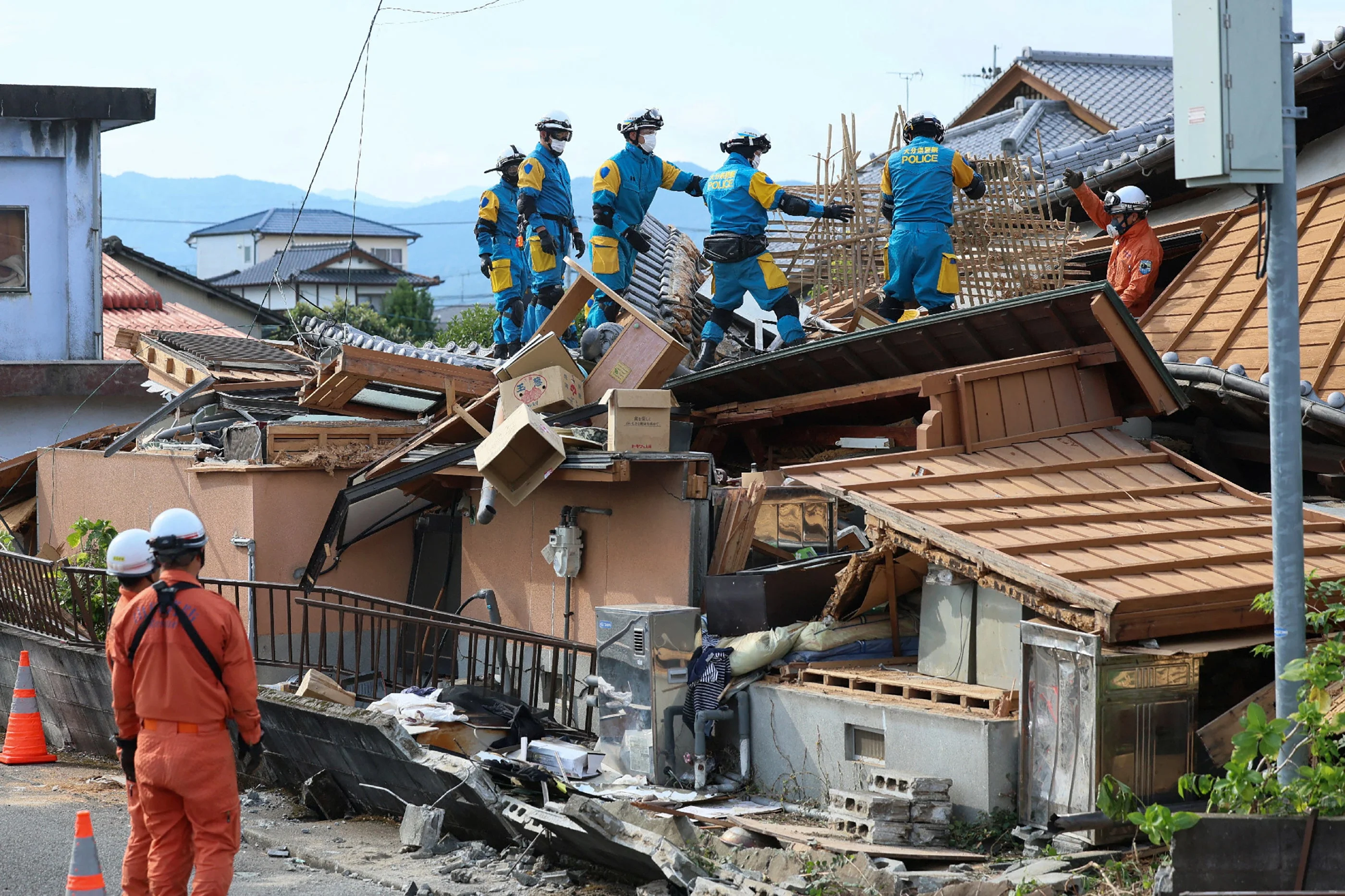 Rescue officials work at the site of a house damaged in an earthquake in Yatsushiro, Japan, last month. The East Asian country saw a 6.8-magnitude quake