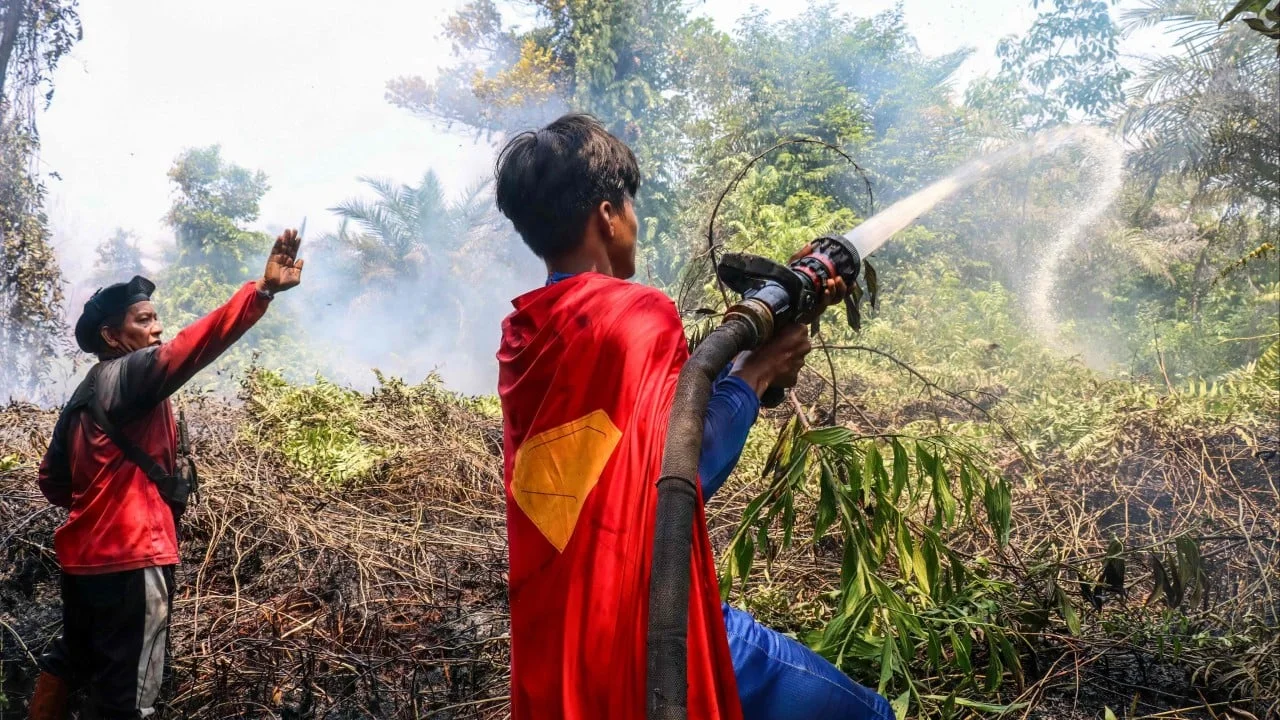 Indonesian teen with ‘Superman’ cape fights haze fires, minister hails ‘forest hero’