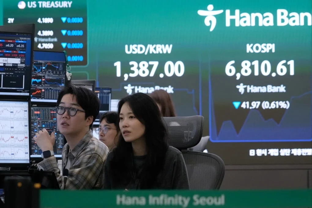 Currency traders watch monitors near a screen showing the Kospi benchmark at the Hana Bank headquarters in Seoul, South Korea, on Friday. Photo: AP