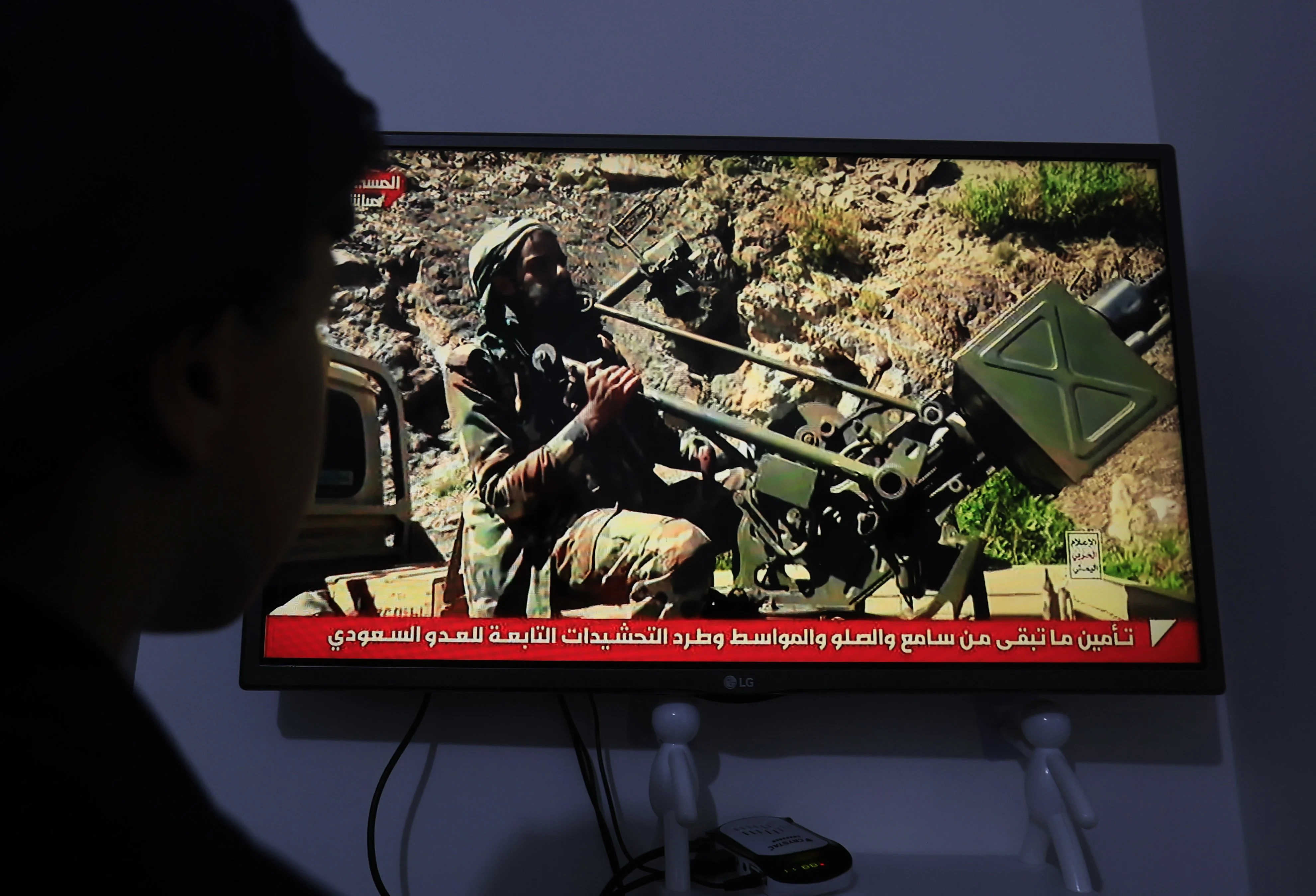 A person watches a television broadcast showing Saudi-backed Yemeni troops in Sanaa, Yemen, on Saturday. Photo: EPA