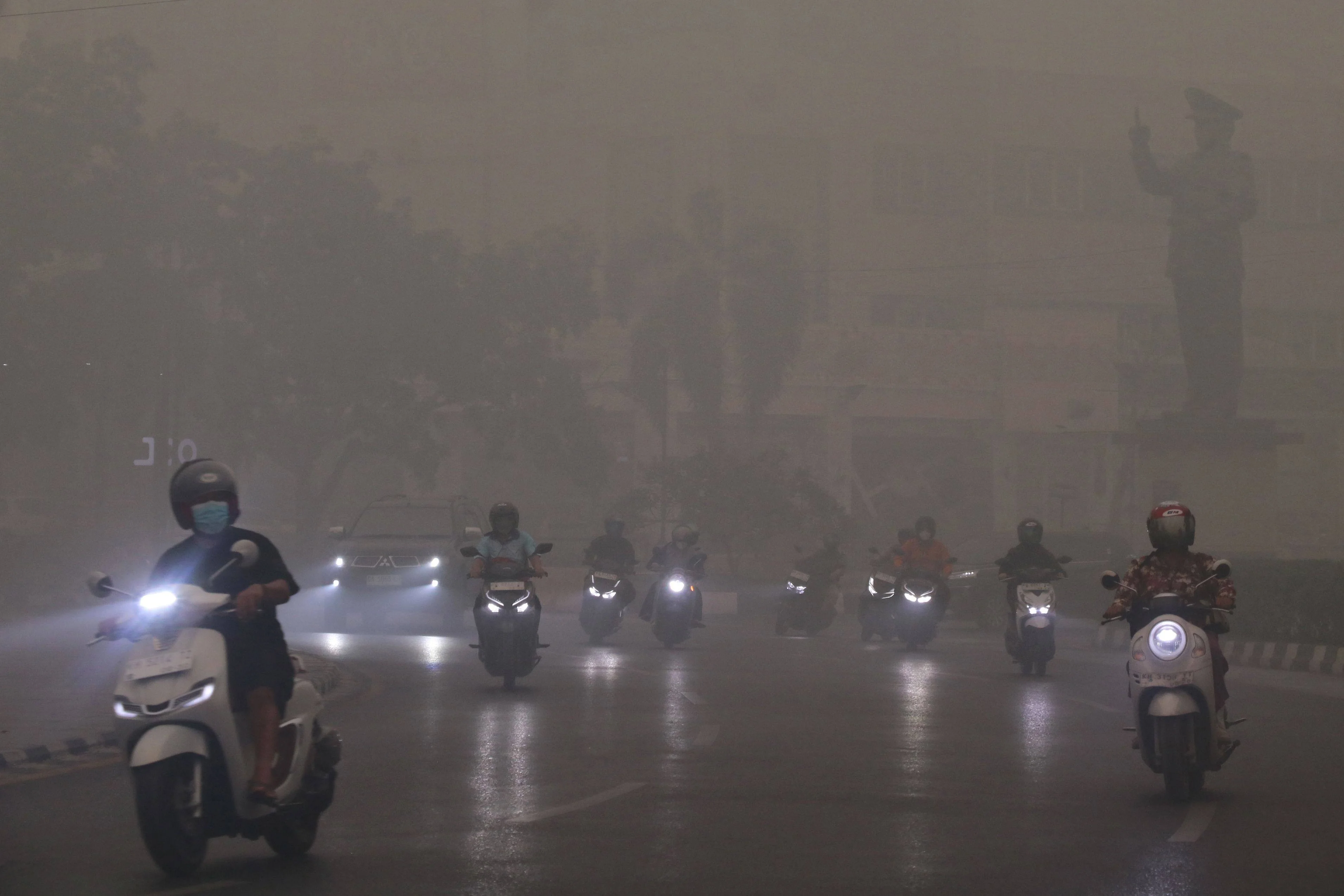 Motorcyclists ride in Palangkaraya, Indonesia’s Central Kalimantan, on Wednesday amid thick haze from forest and land fires in the region. Photo: AFP