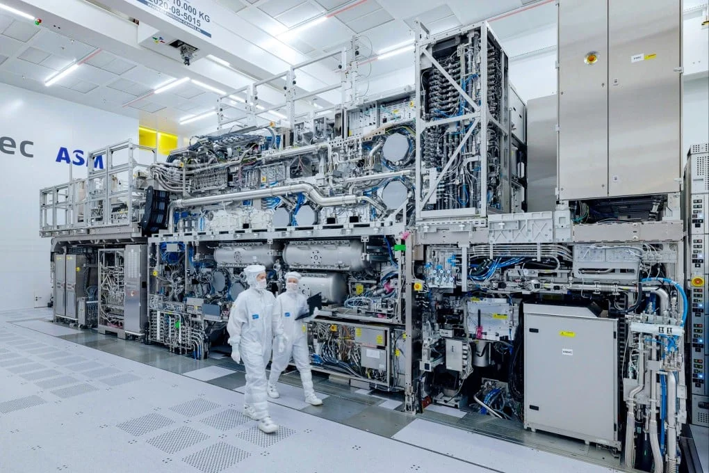 ASML engineers walk past an extreme ultraviolet (EUV) chipmaking machine at a company facility in Veldhoven, the Netherlands. Photo: Handout